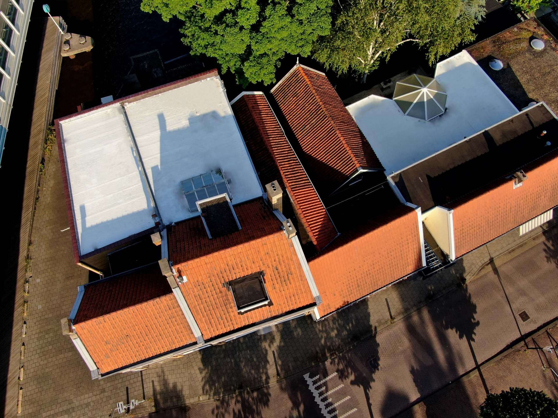 siliconen dakcoating Witte dakcoating bij twee winkelpanden en een woonhuis Hommersen & Beerepoot dakcoating